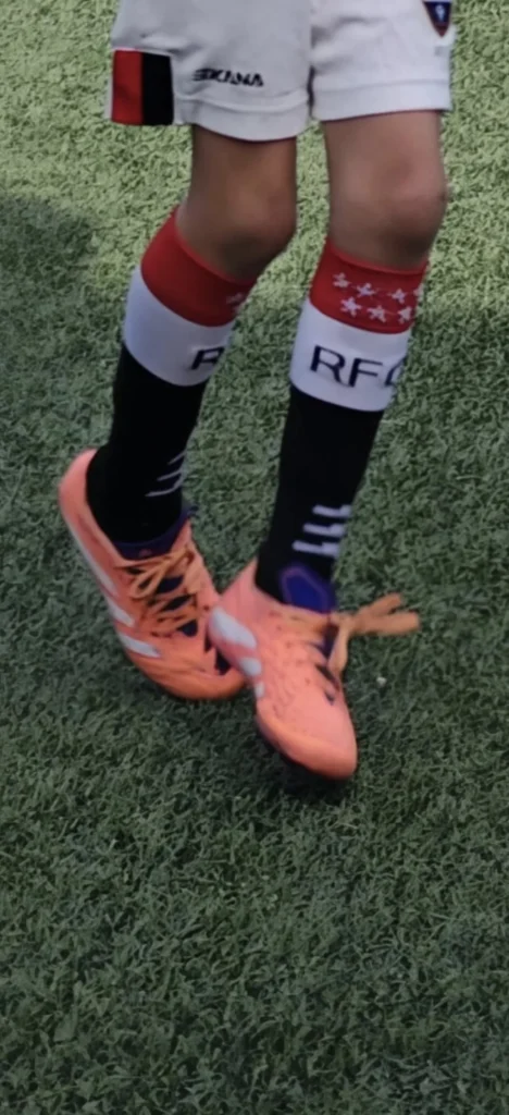 Botas adidas Predator coral infantiles en césped artificial